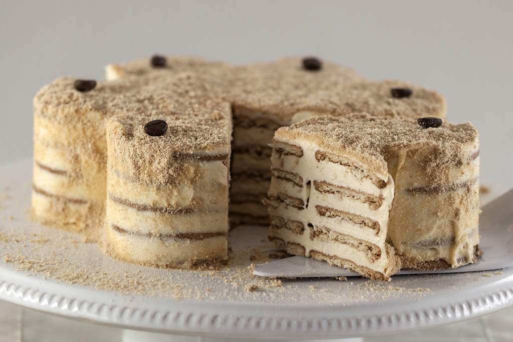 Bolo de Bolacha português, com camadas de bolacha Maria embebidas em café e creme suave, servido numa mesa de Thanksgiving. Uma sobremesa perfeita para partilhar com a família, adicionando um toque de tradição e nostalgia à celebração.